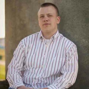 Garrett Light, Ewing sarcoma survivor, squints in a striped shirt for a senior picture. 